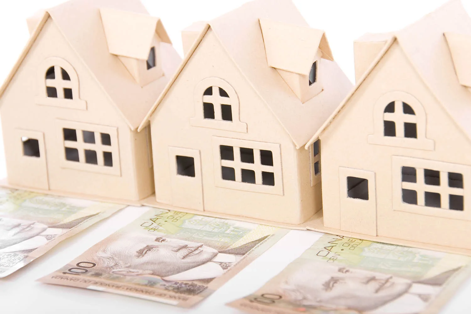 three little houses sitting on money