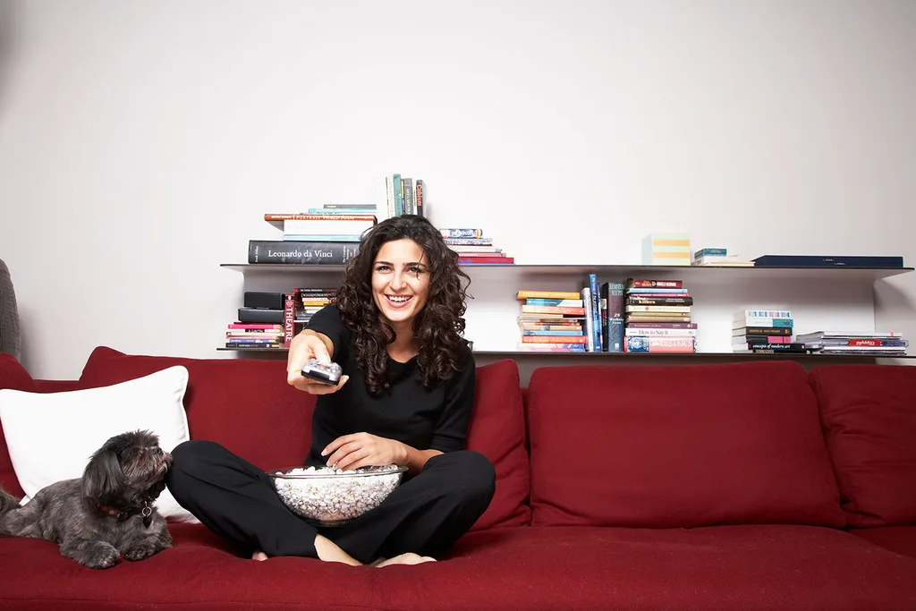 woman on couch with popcorn and dog