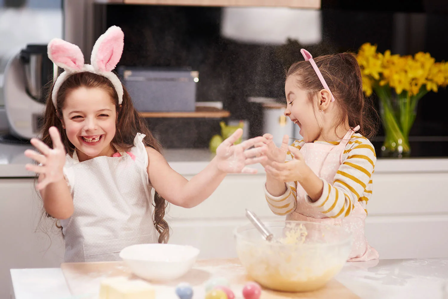 girls making easter eggs in kitchen