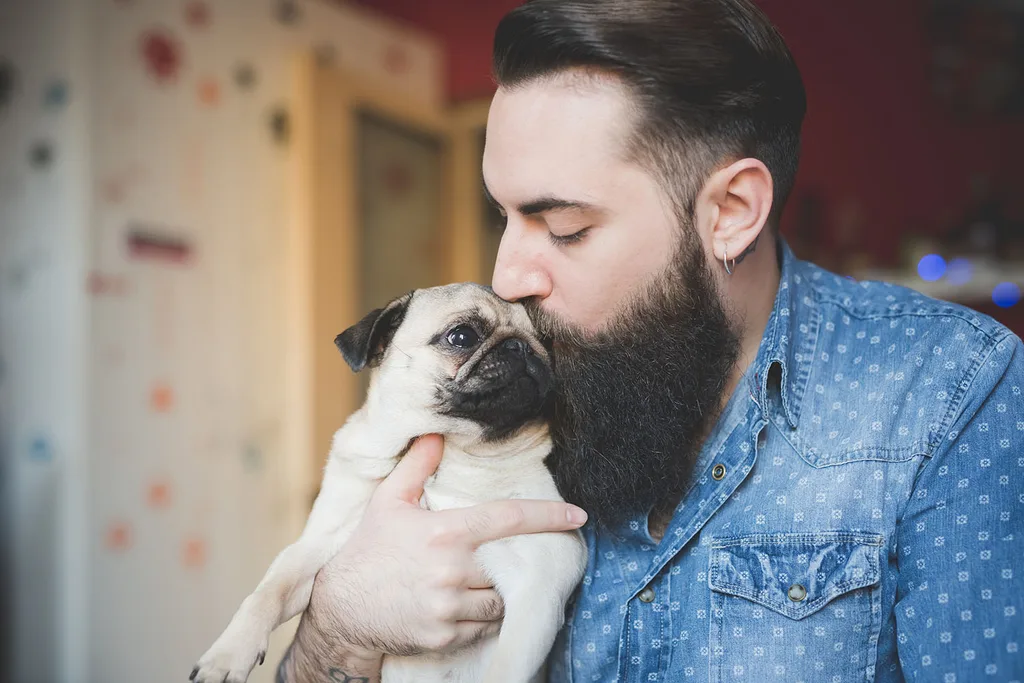man with pug puppy