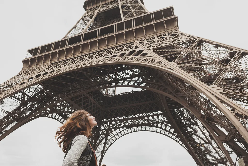 woman looking up at eiffel tower