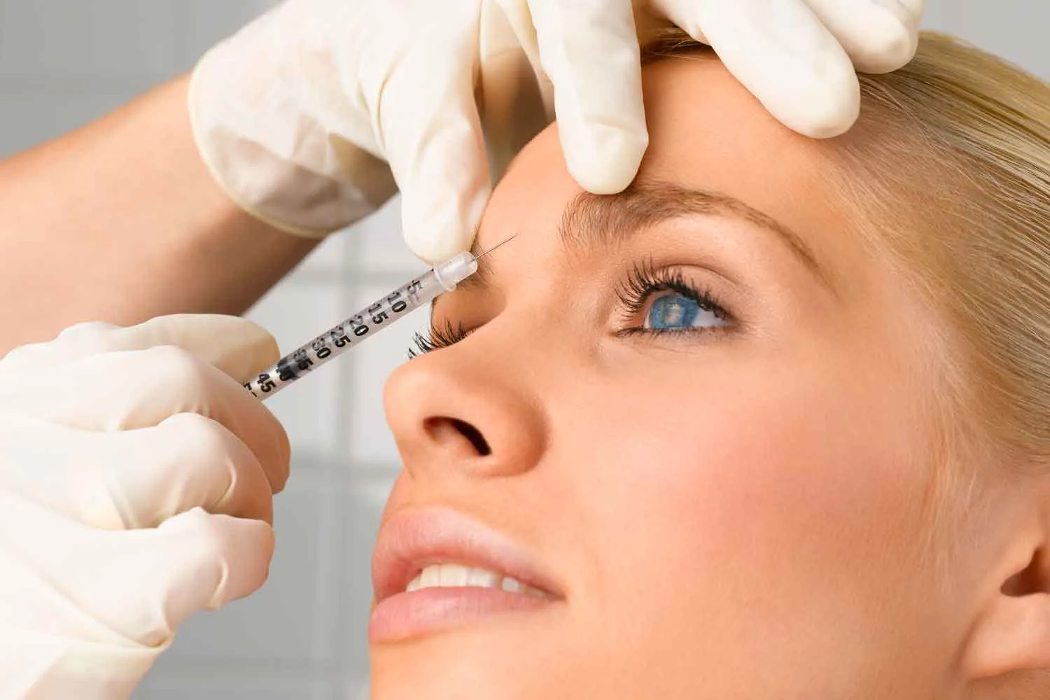 Needle injecting botox into face