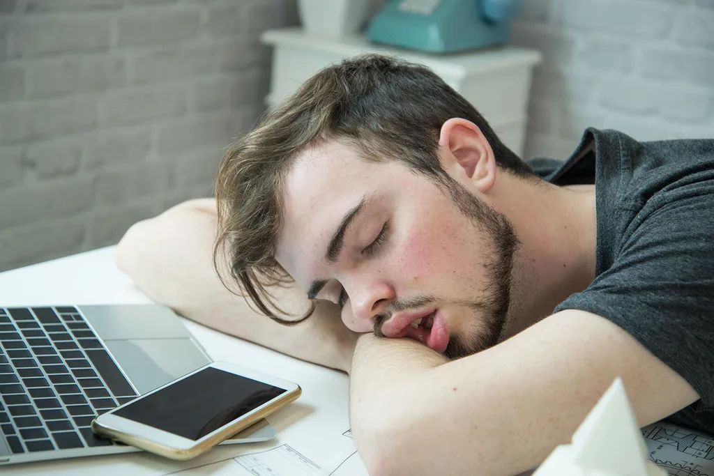 man sleeping on desk