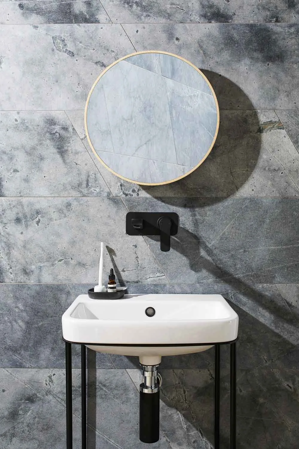Grey marble tiles behind a white bathroom basin.