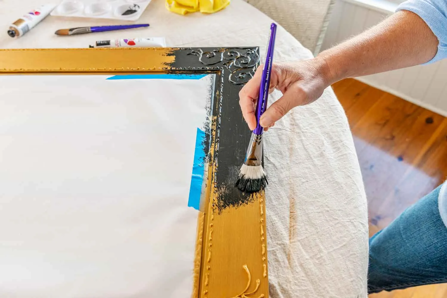 Apply black paint to gold mirror frame