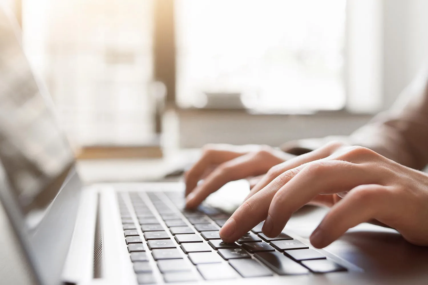 hands on laptop keyboard
