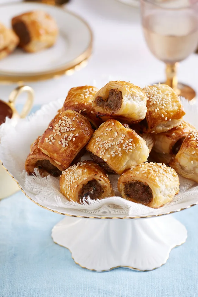 Easy beef and onion sausage rolls on a cake stand