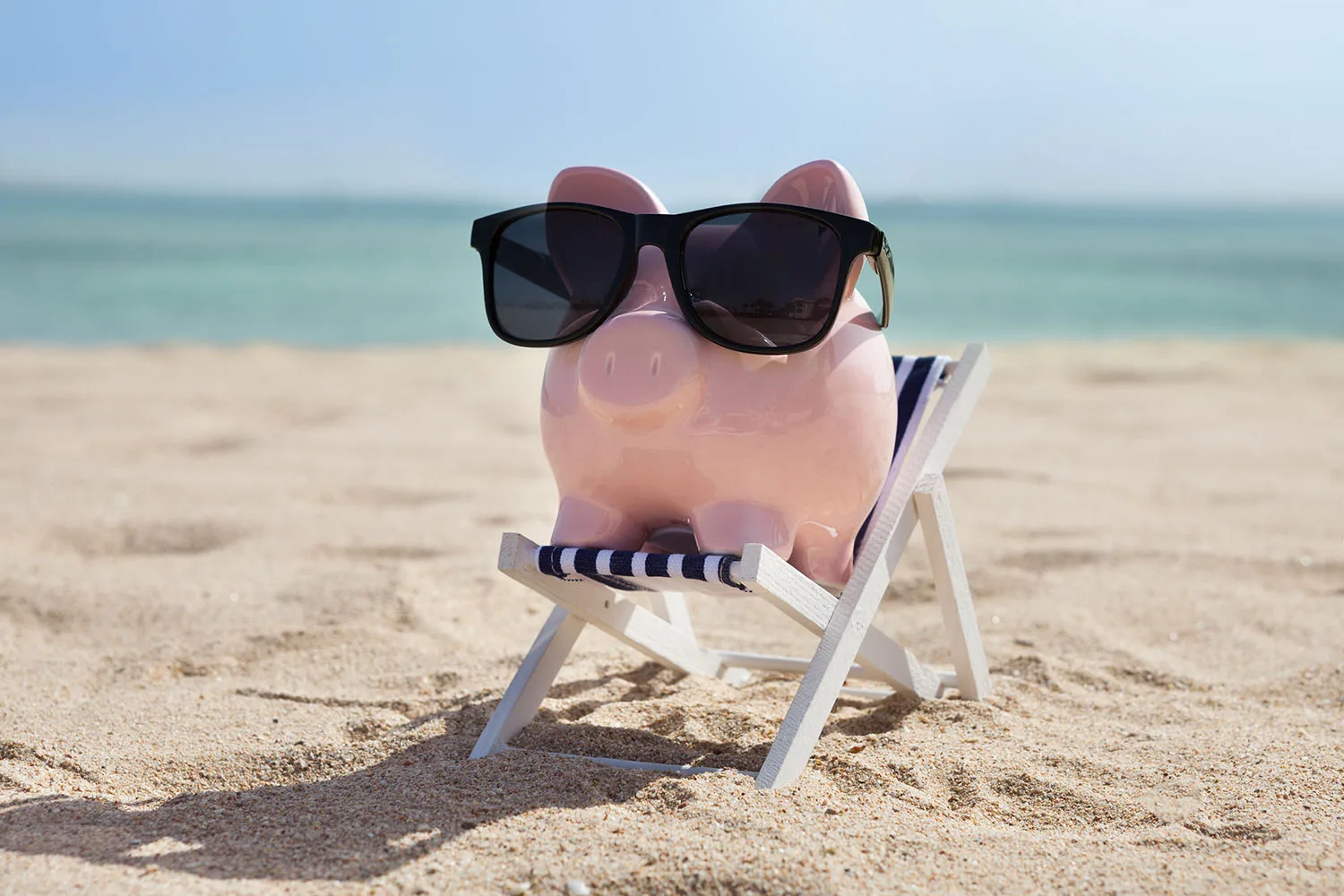 happy piggy bank on beach