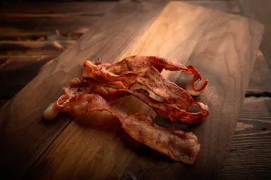Rashes of bacon on a wooden board