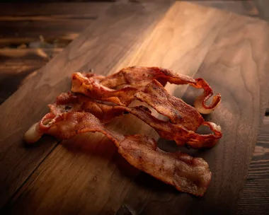 Rashes of bacon on a wooden board