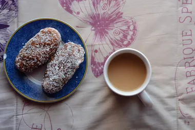 2 koesisters sitting on a plate with a cup of tea