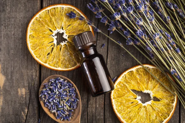 A bottle of essential oils with sticks of lavendar