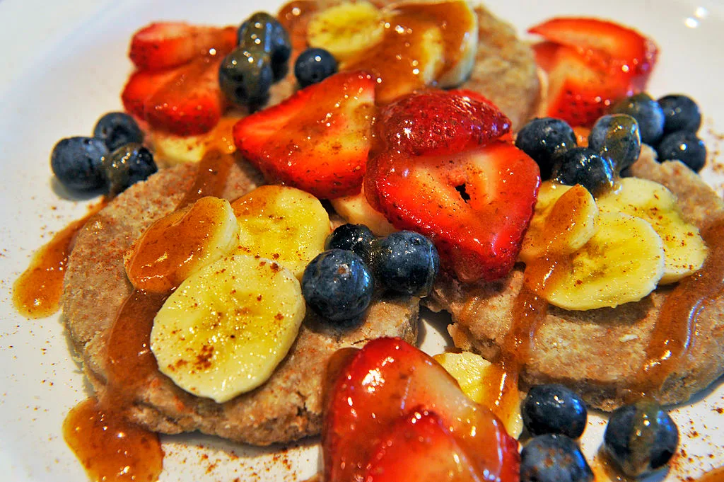 Raw vegan pancakes served with fruit and agave syrup by Cafe Green, a vegan restaurant in Washington DC