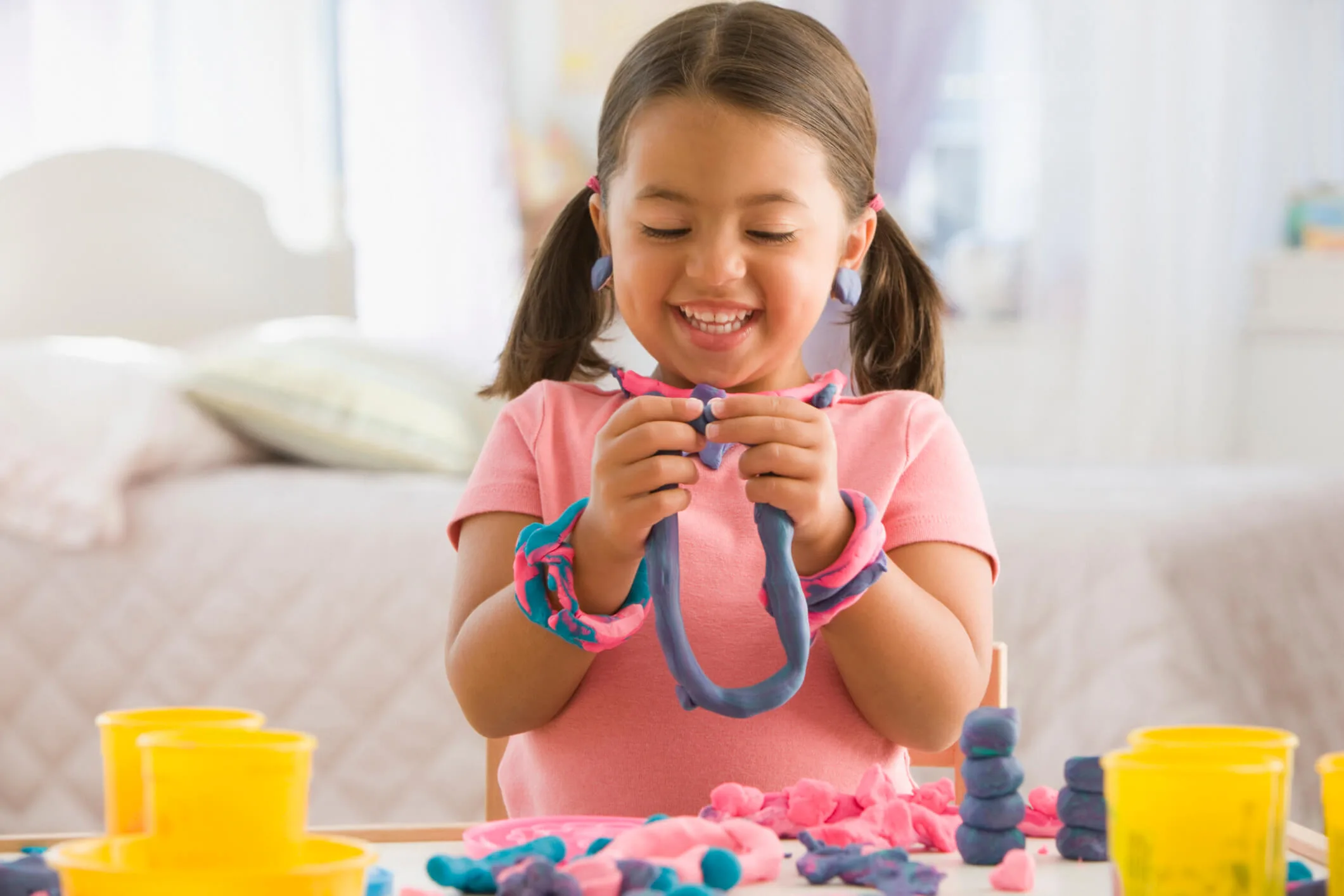 A young girl playing with purple playdough