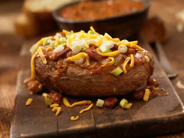 A baked jacket potato with cheese, sour crime & chives