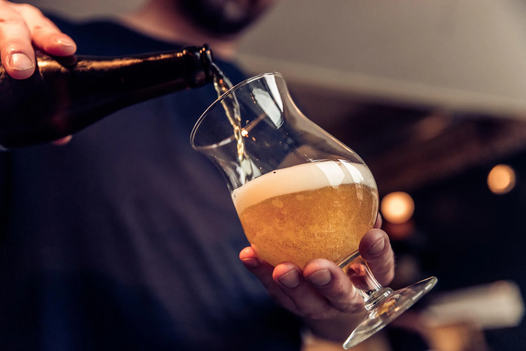 A man pouring alcohol into a wineglass