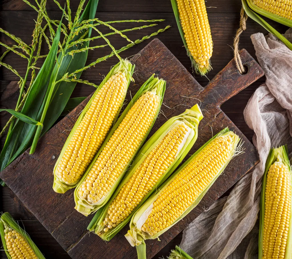 Corn cobs on a wooden chopping board