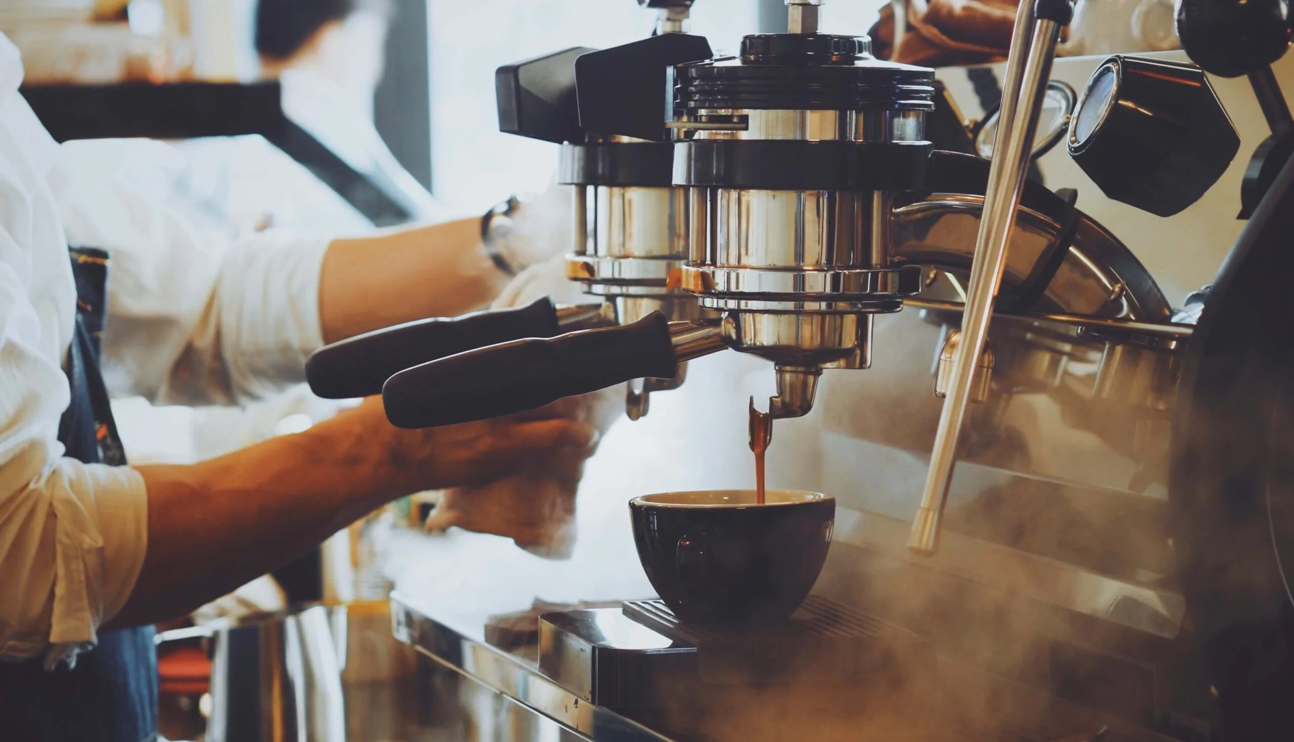 A barista brewing a coffee in a cafe