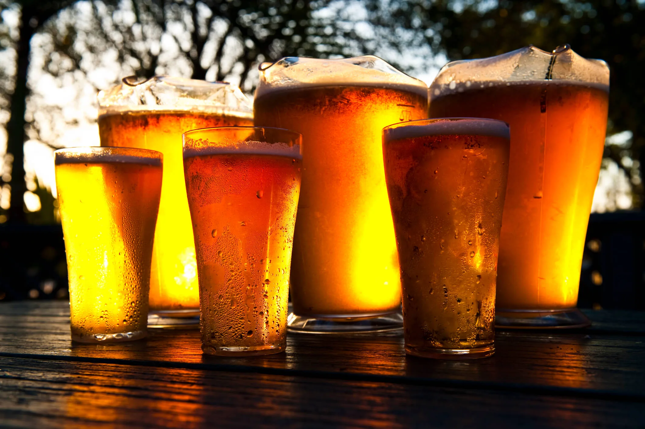 Glasses of beer on a wooden outside table