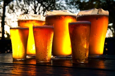 Glasses of beer on a wooden outside table