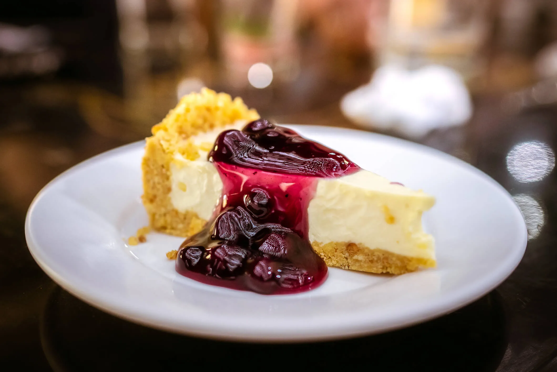 Slice of blueberry cheesecake with berry coulis