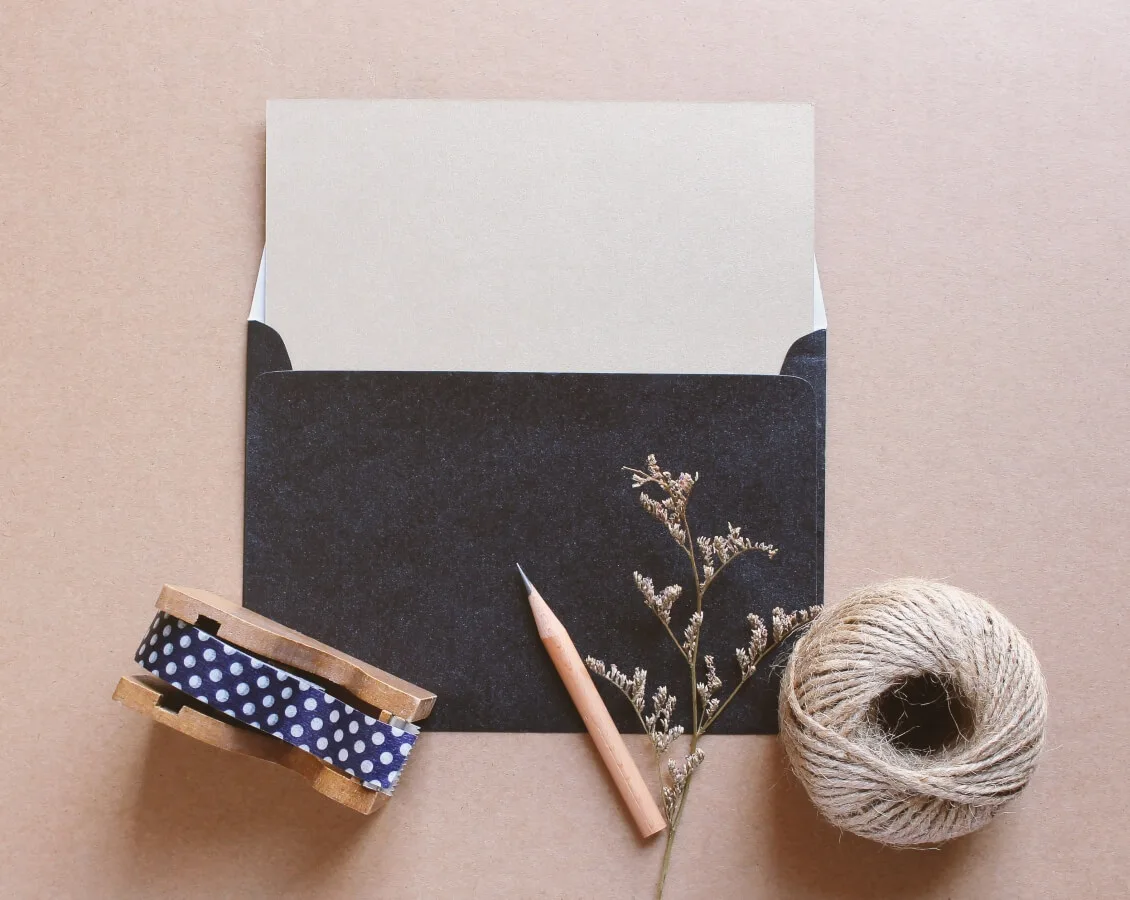 Black envelope with string, a pencil and sticky tape