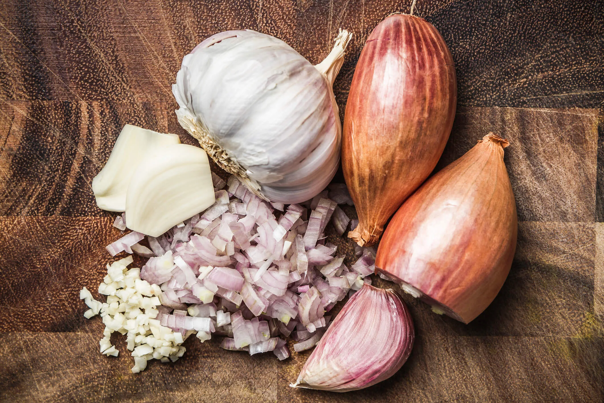 Onion, garlic & green curry paste on a wooden chopping board
