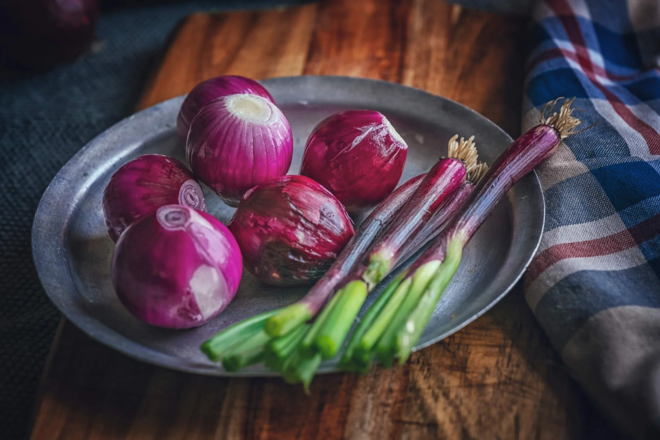 Red onions and red spring onions on a silver tray