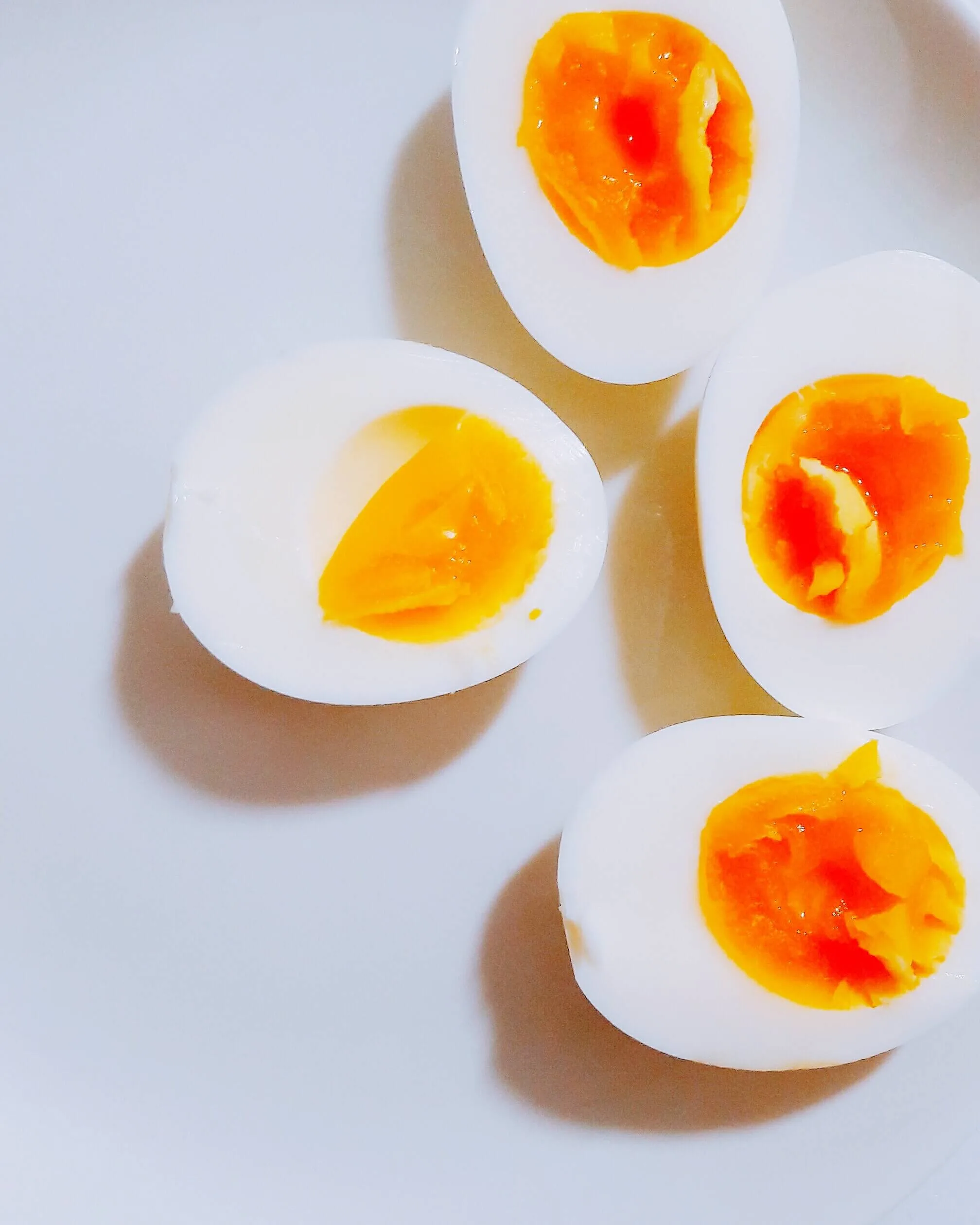 Two soft boiled eggs on a white bench