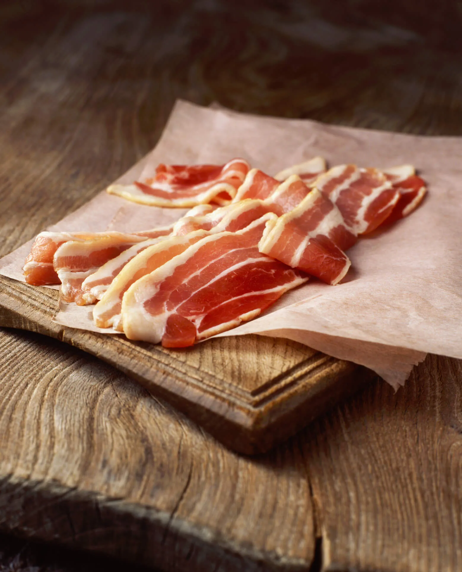 Rashers of raw bacon on baking paper