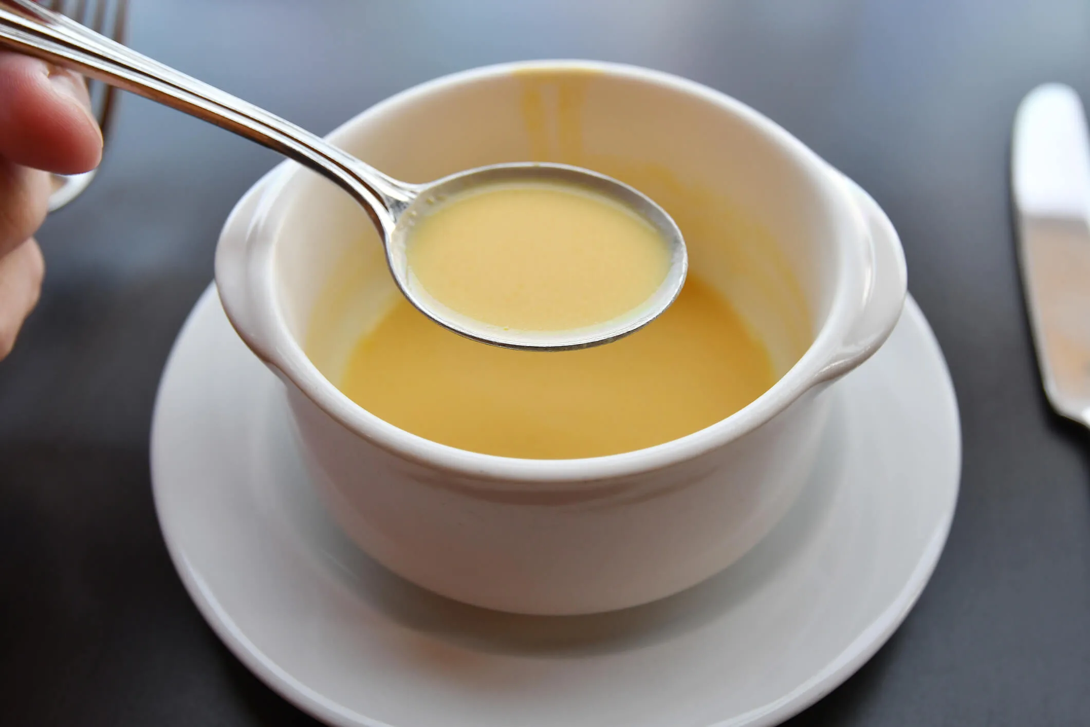 A person eating pumpkin with a spoon