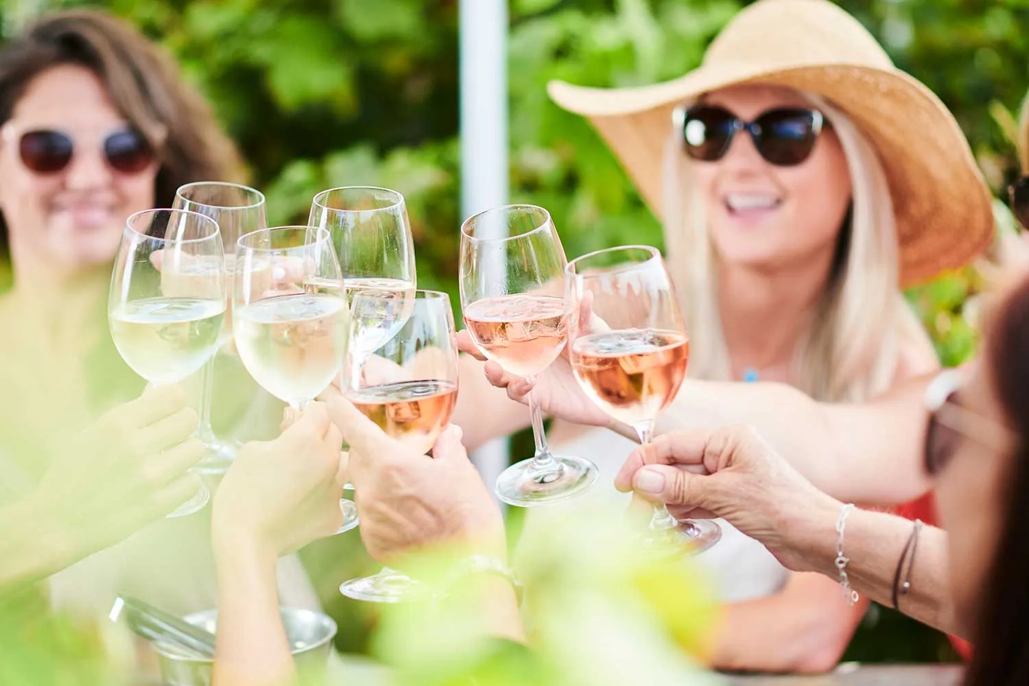 People saying cheers with rose wine