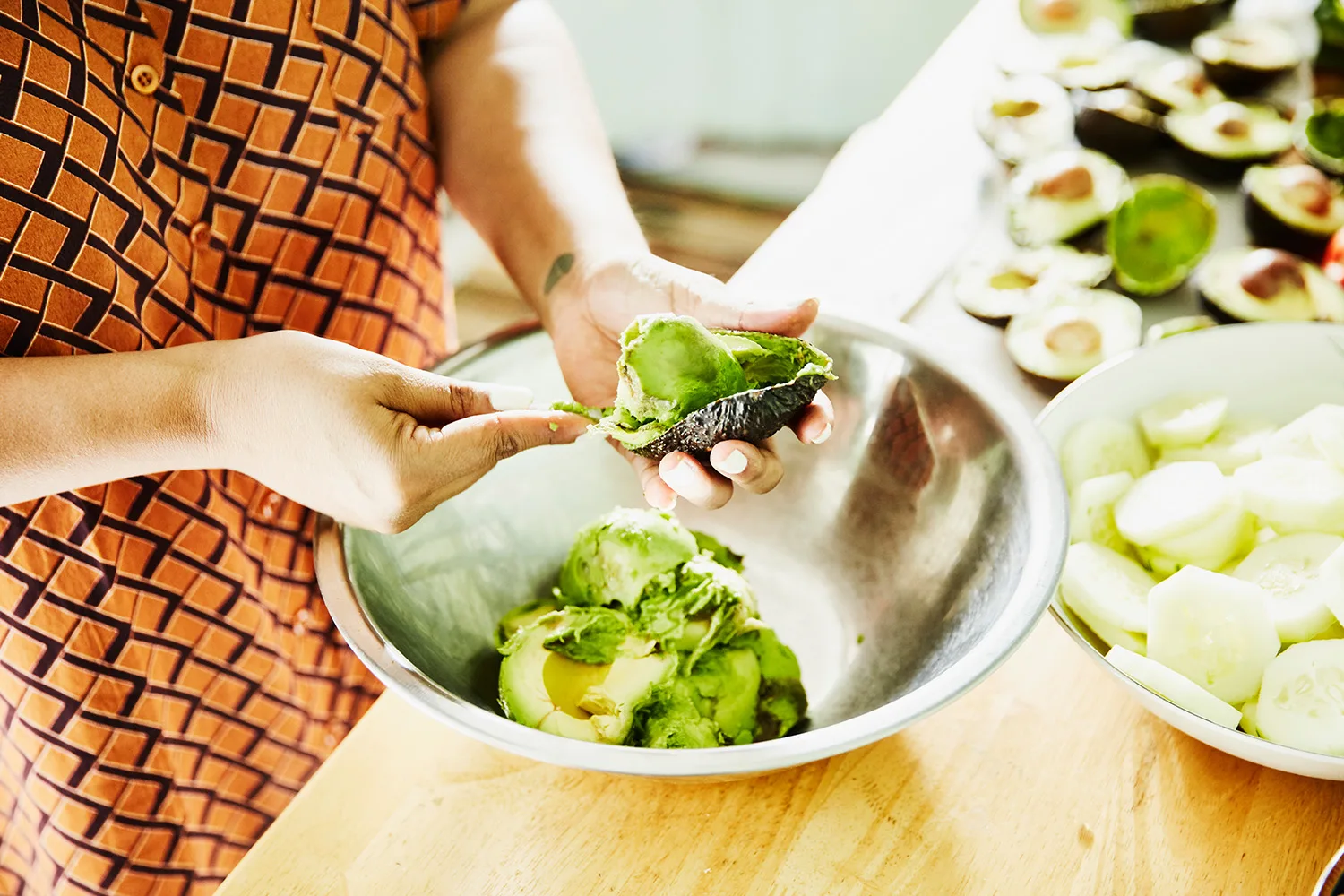 avocado being spooned into a bowl