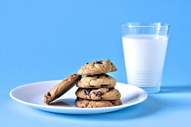 choc chip cookies on plate with glass of milk