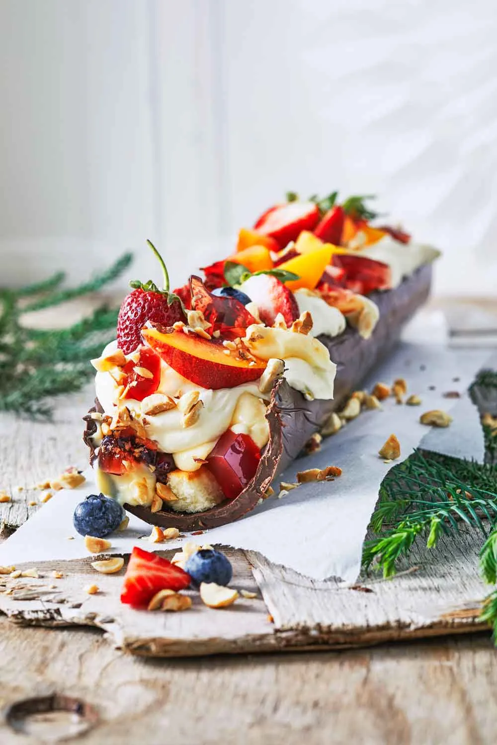 Chocolate mousse trifle in half log of tempered chocolate with fruit on top