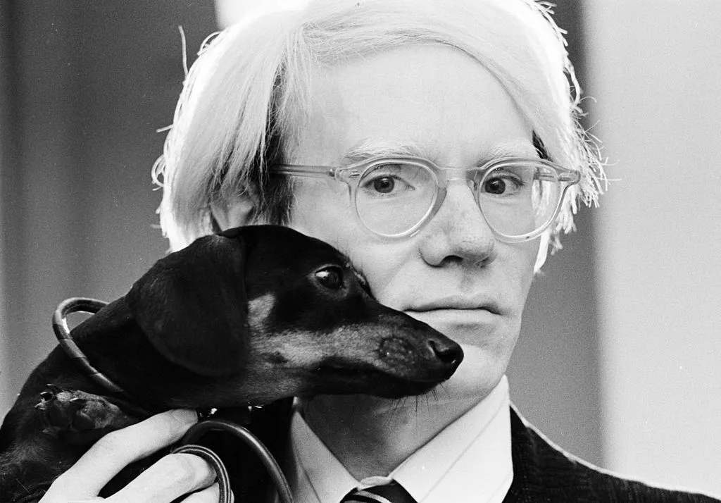 Andy Warhol holding his dachshund, Lump