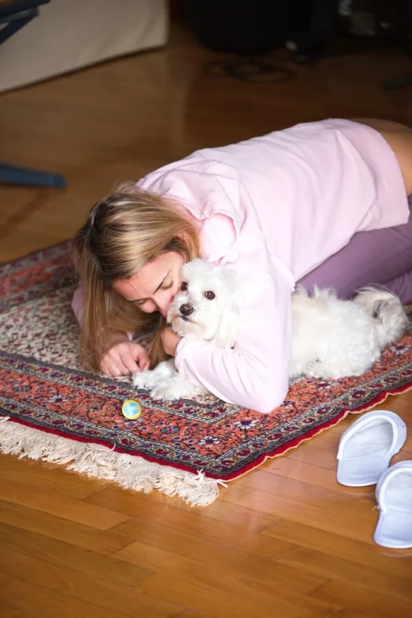 A woman hugging a Maltese dog