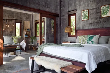 A rustic styled bedroom with concrete floors and walls