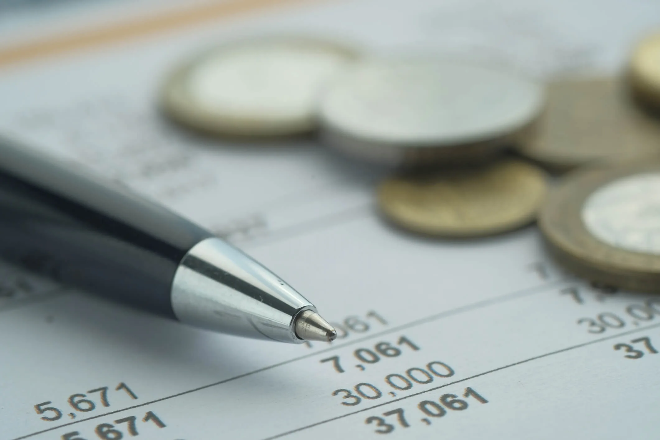 A financial document with a pen and coins