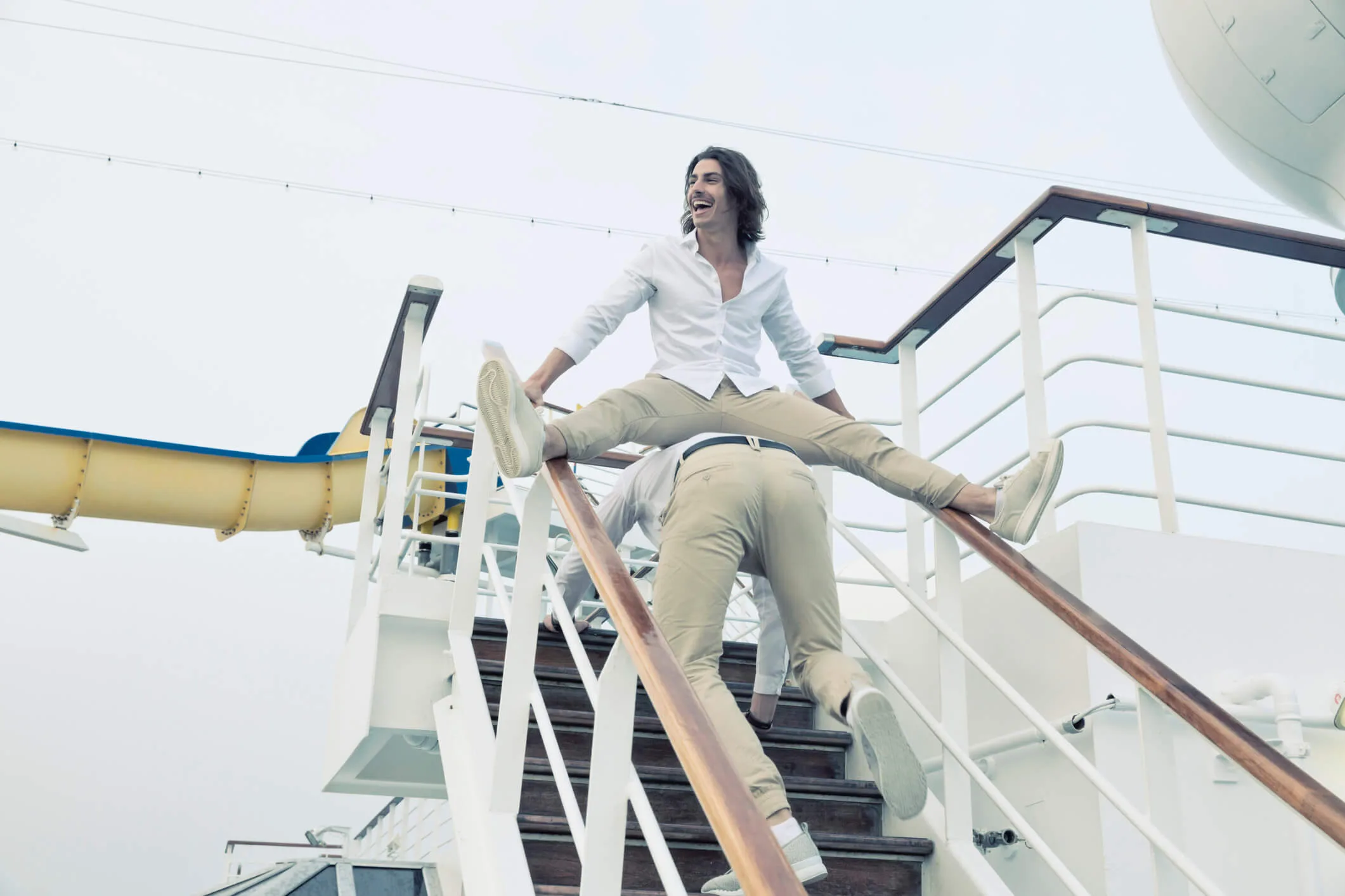 Two friends fooling around on the staircase of a cruise ship