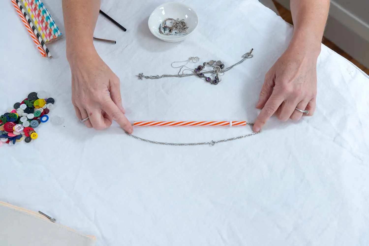 necklace chain threaded into straw for storage