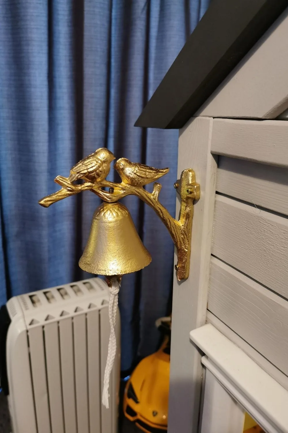 gold fancy bell attached to side of cubby