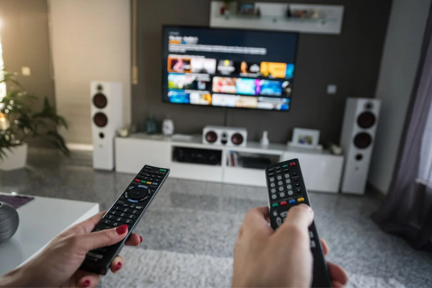 Two people clicking remote at tv