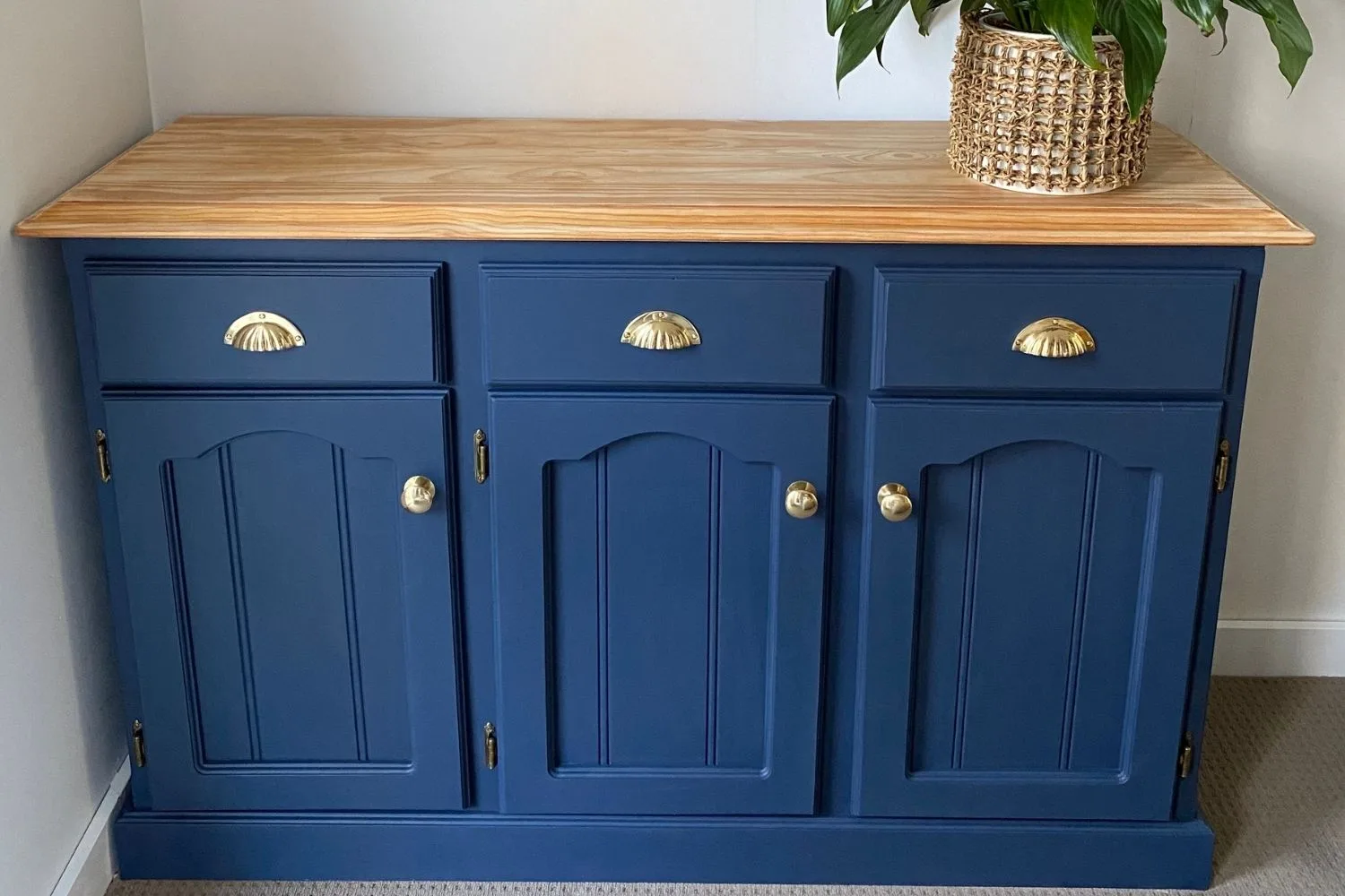 blue cabinet with timber top and plant