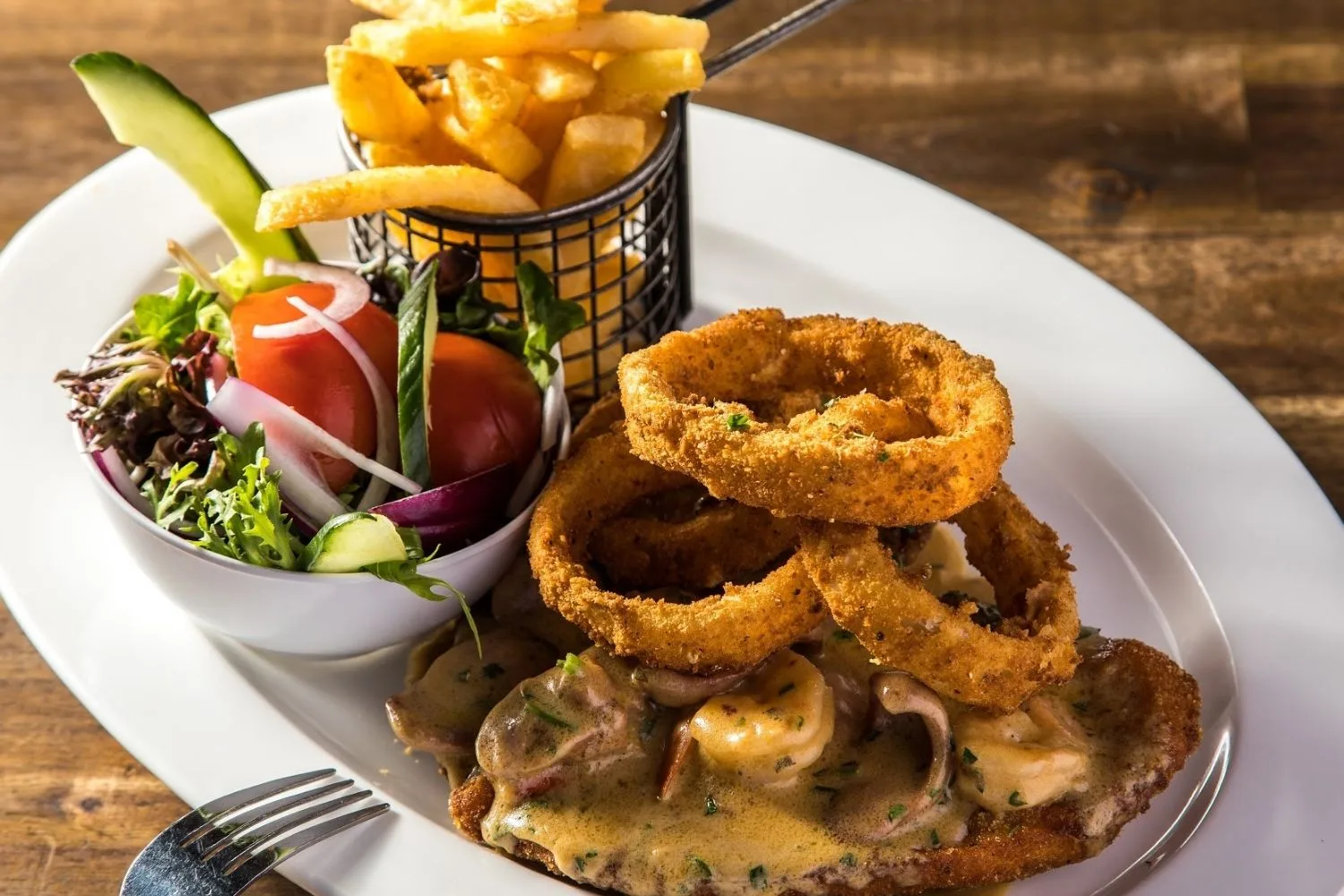 schnitzel with onion rings salad and chips