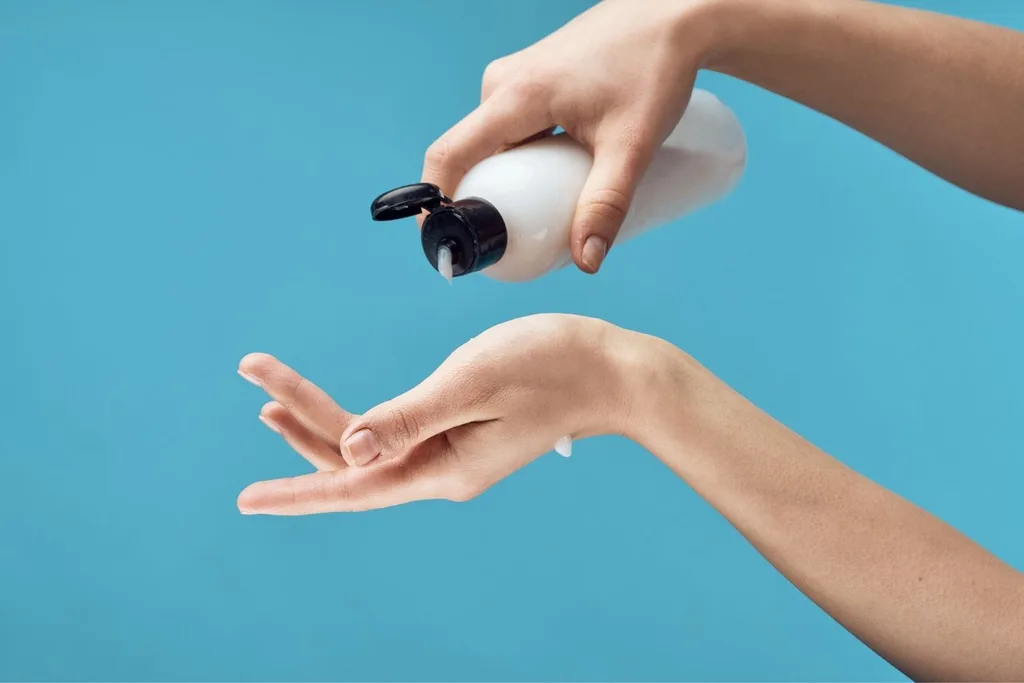 Womans hands apply sunscreen