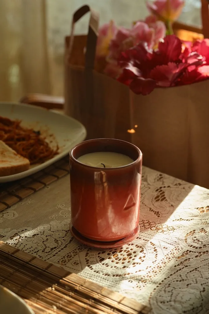 red cased candle in sunlight