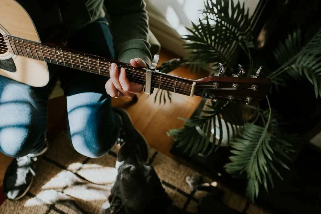 someone playing guitar by plants