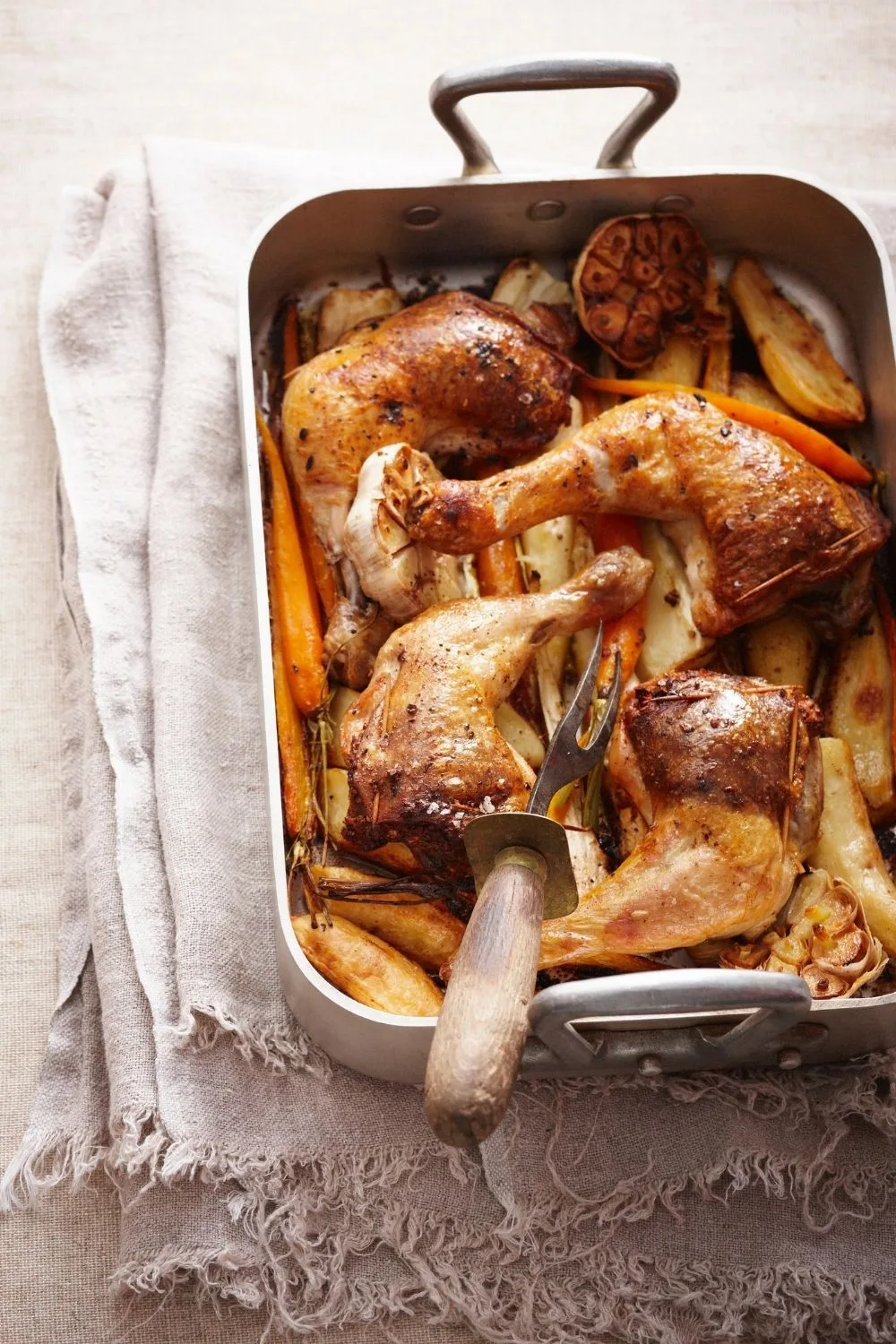 Baked chicken thighs in a roasting pan with vegetables
