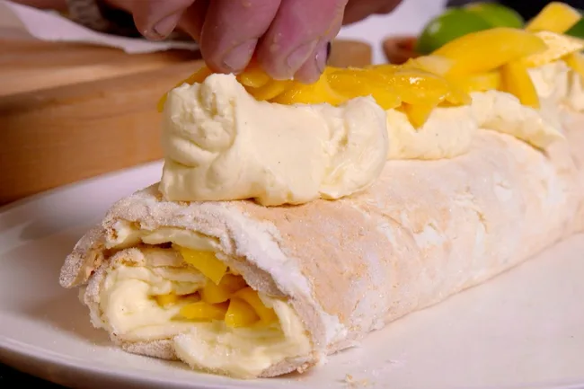 Vanilla and mango pavlova roll